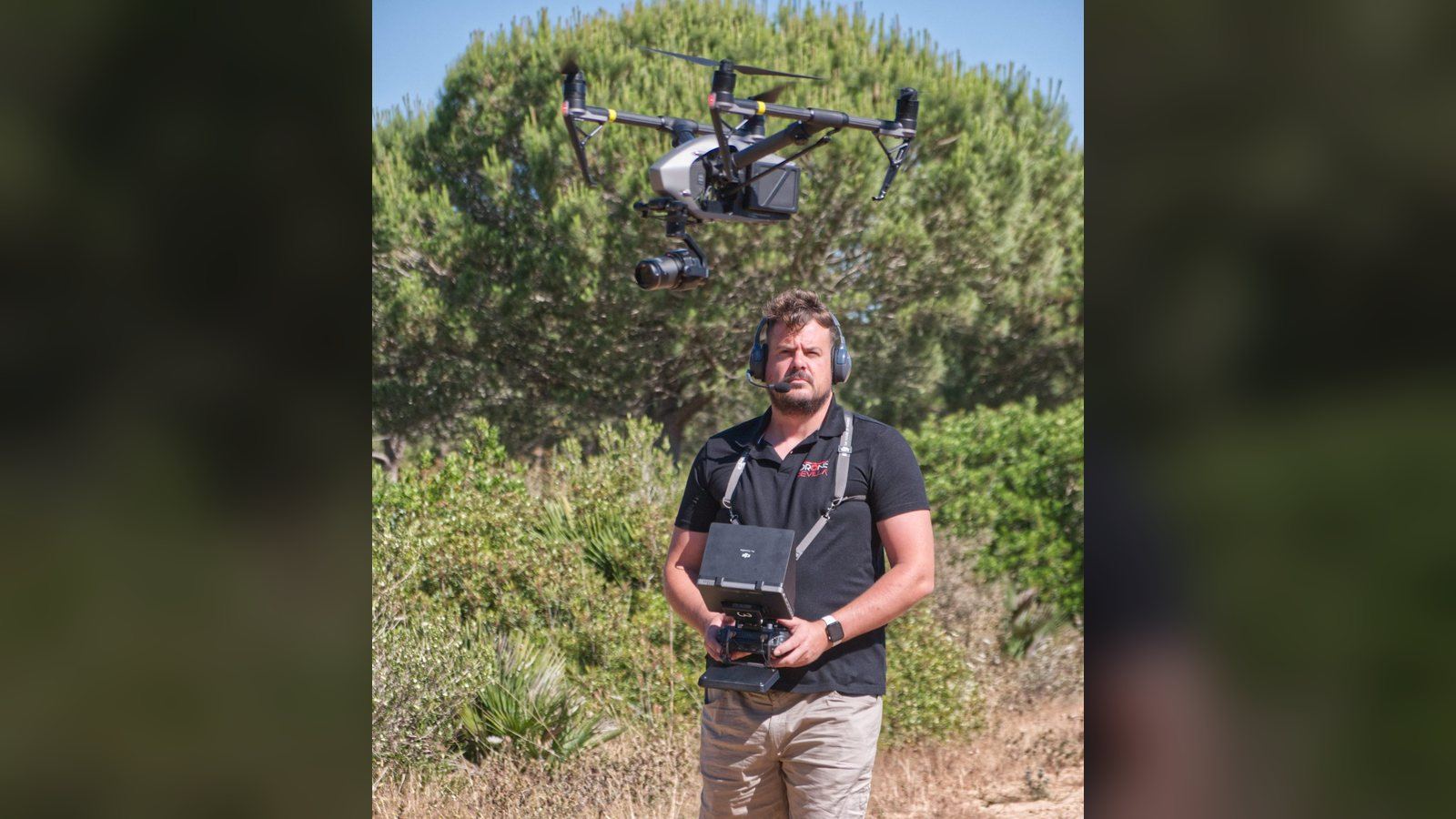 Piloto operando un dron en vuelo en un entorno de monte abierto
